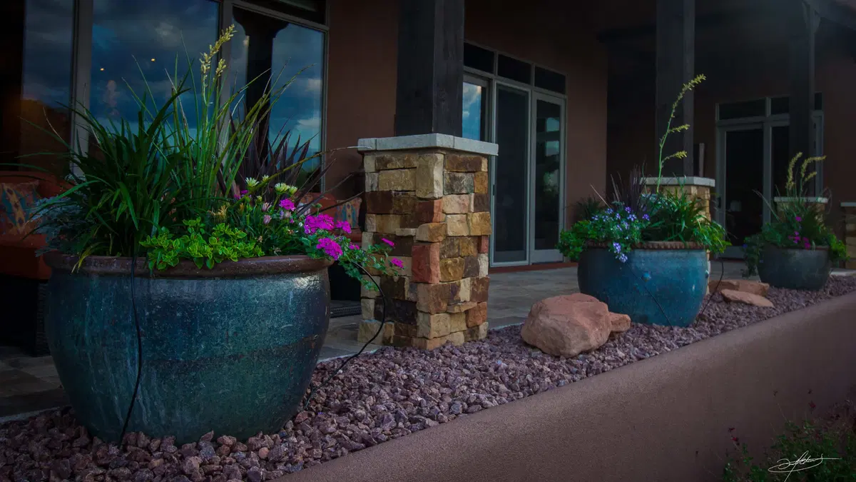 columns lining a porch, with planted blue pottery in between