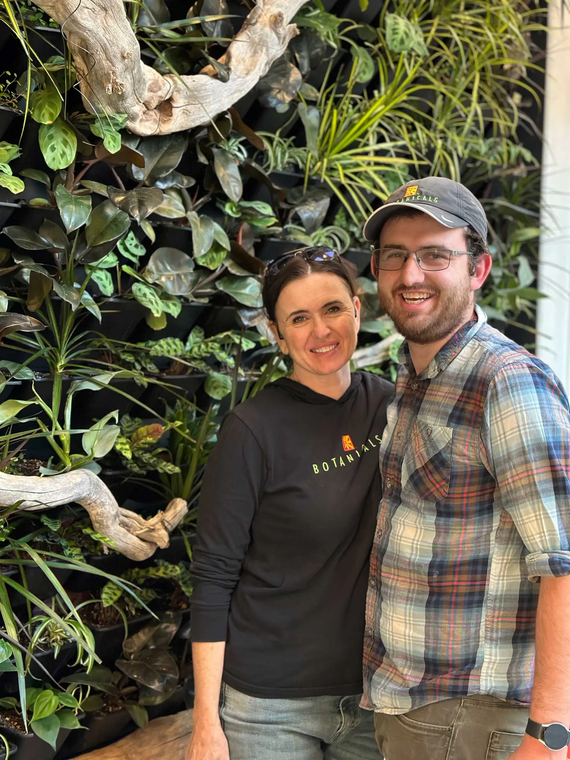 Nicole Hancock and Dallin Warner. Mother and son standing in front of a living wall installation