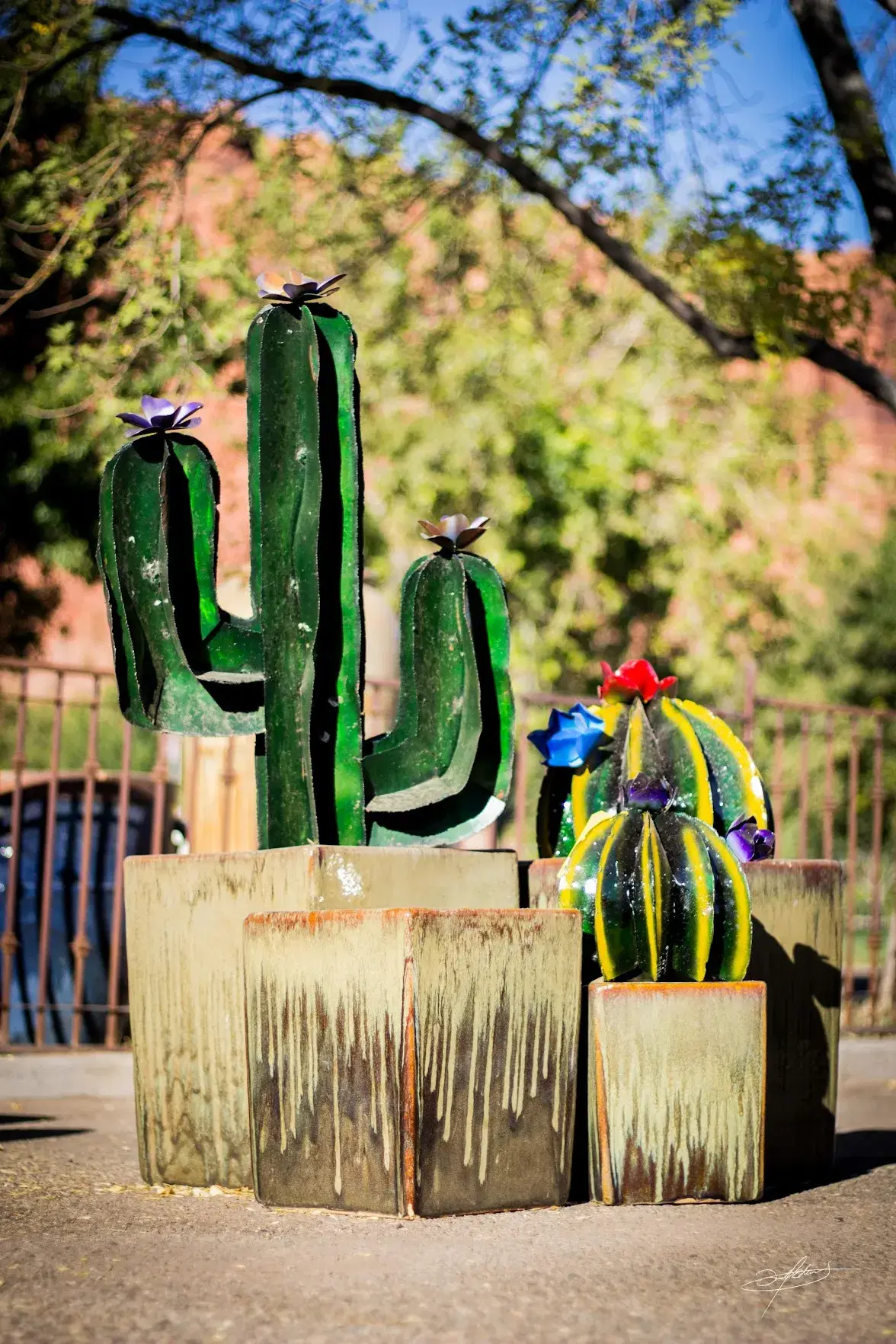 ceramic pottery in the foreground, human-sized metal cactus in the background