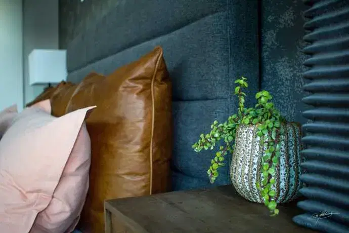 a small pot planted with a succulent on a nightstand next to a bed