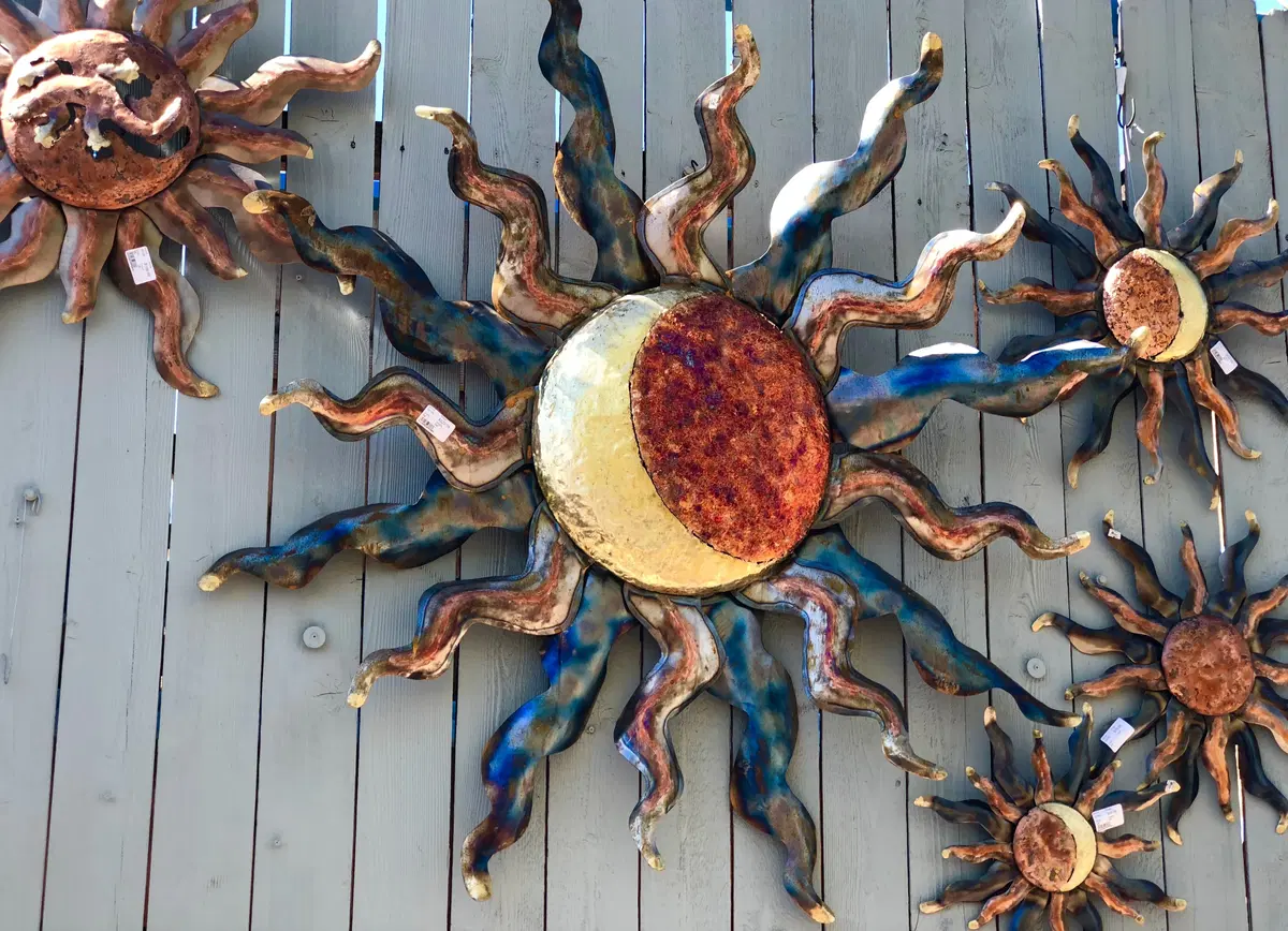 a metal, multi-toned sun hanging outside