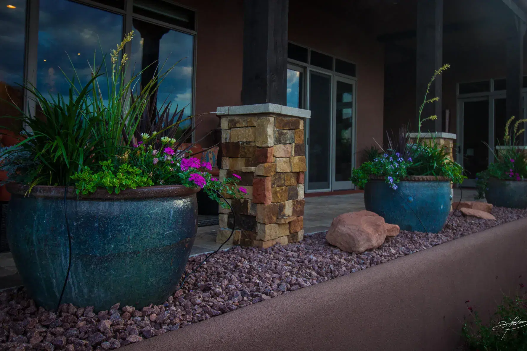 planted, glazed pottery placed between columns of a home