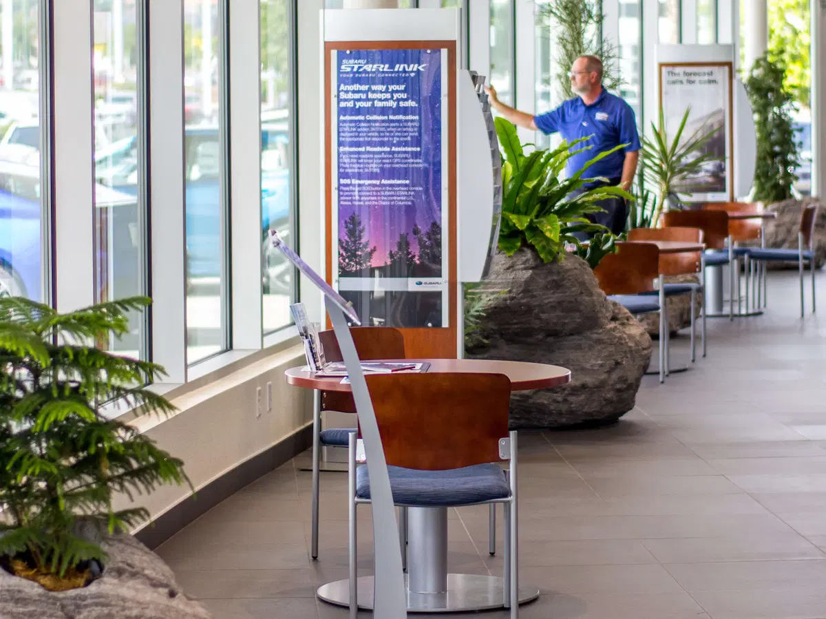 tables, chairs, and a salesman in a plantscaped waiting area