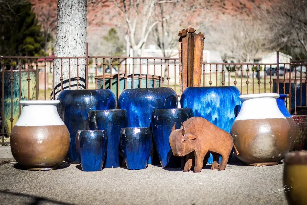 a collection of blue pottery, with a rustic metal bison in front