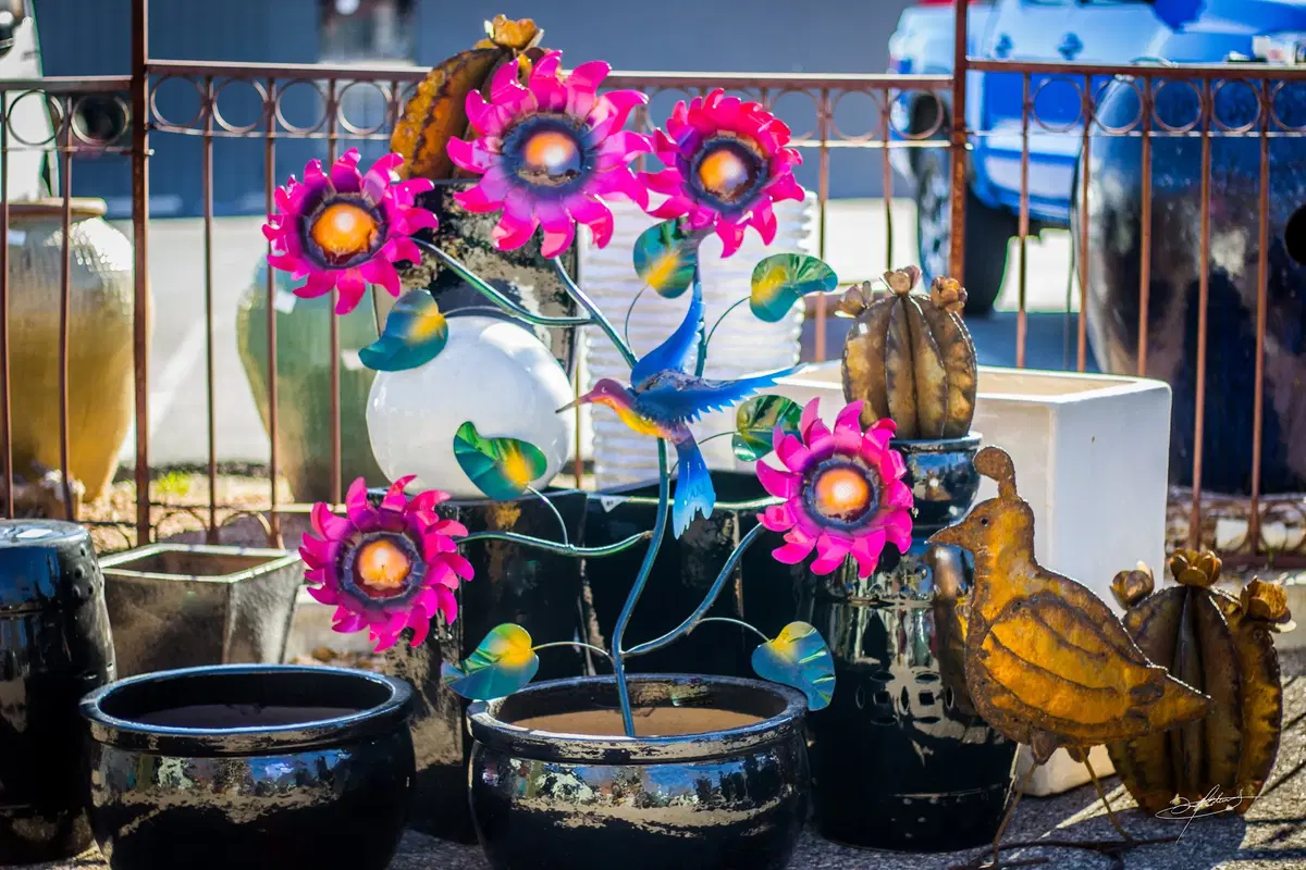 pink metal flowers emerging from black pottery