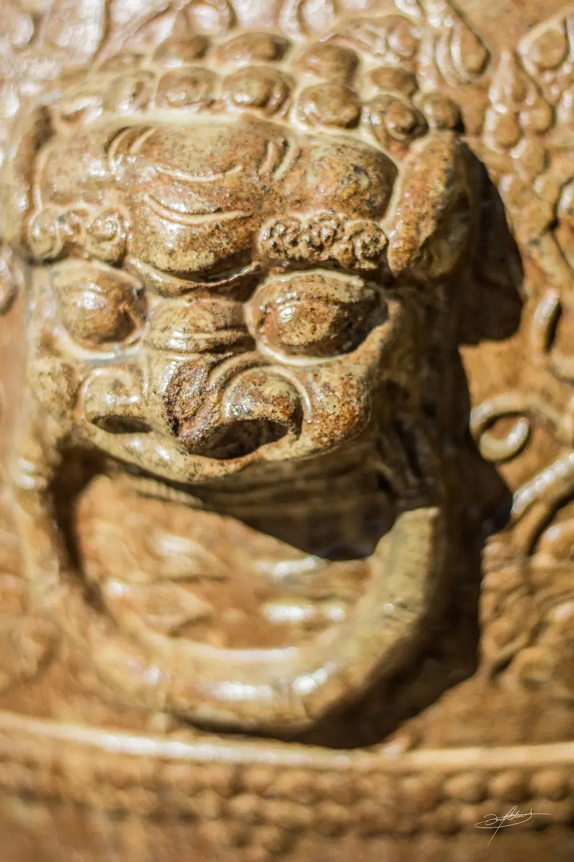 intricate, 3d art on a pot resembling a door knocker