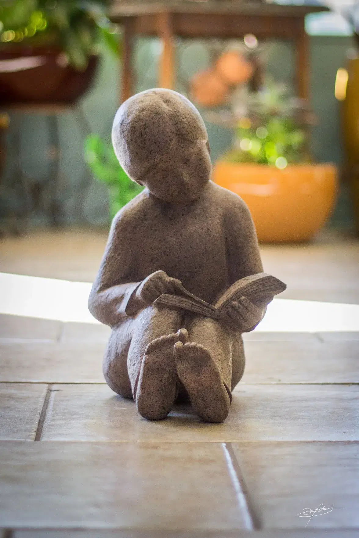 a small statue of a child sitting and reading