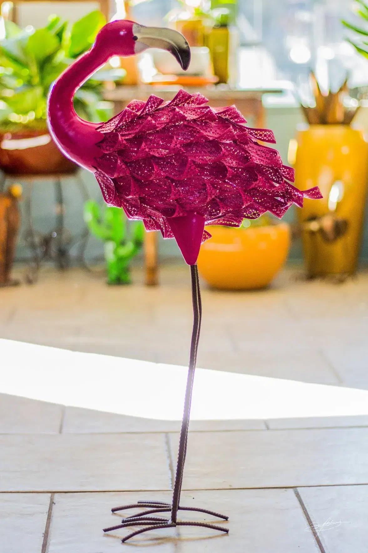 a pink metal flamingo standing on one leg
